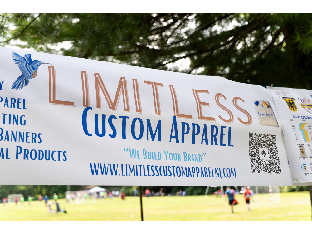 Large printed Limitless Custom Apparel banner at a sports field