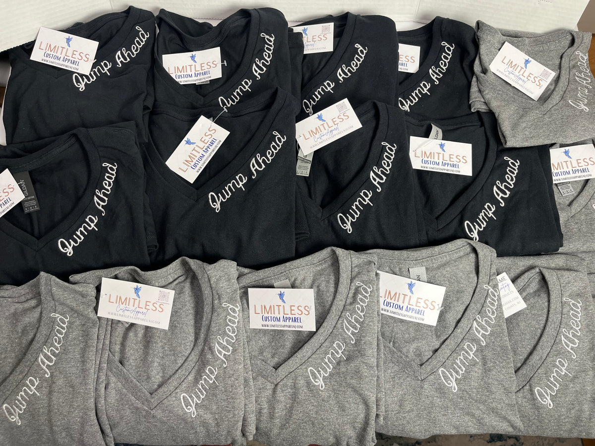Stacks of custom embroidered V-neck tees ready to ship